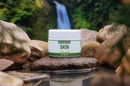 Formula Swiss CBD Skin balm jar beside a waterfall